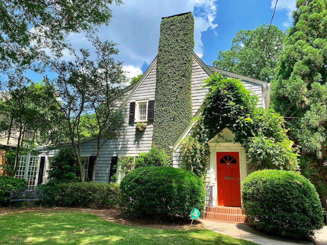 Classic Atlanta-style brick home with a 'For Sale' sign in the manicured front yard on a bright, sunny day, representing t...