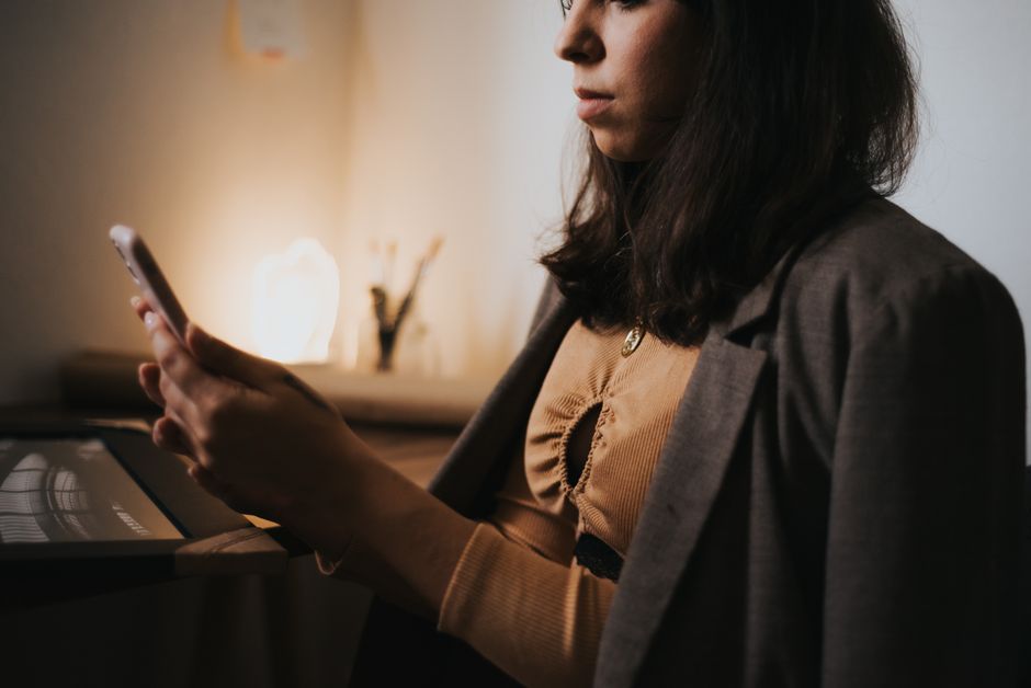 A person relaxing in a minimalist smart home, where warm ambient lighting adjusts automatically, showcasing technology that proactively creates a comfortable environment.
